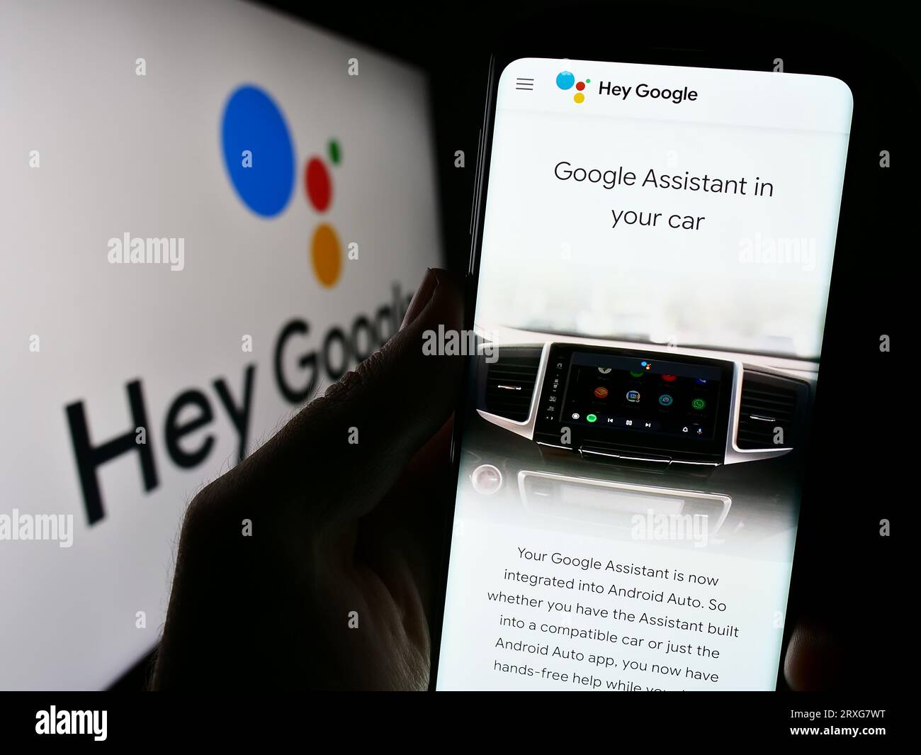 Person, die ein Mobiltelefon mit Webseite der virtuellen Assistenzsoftware Google Assistant auf dem Bildschirm mit Logo hält. Konzentrieren Sie sich auf die Mitte der Telefonanzeige. Stockfoto