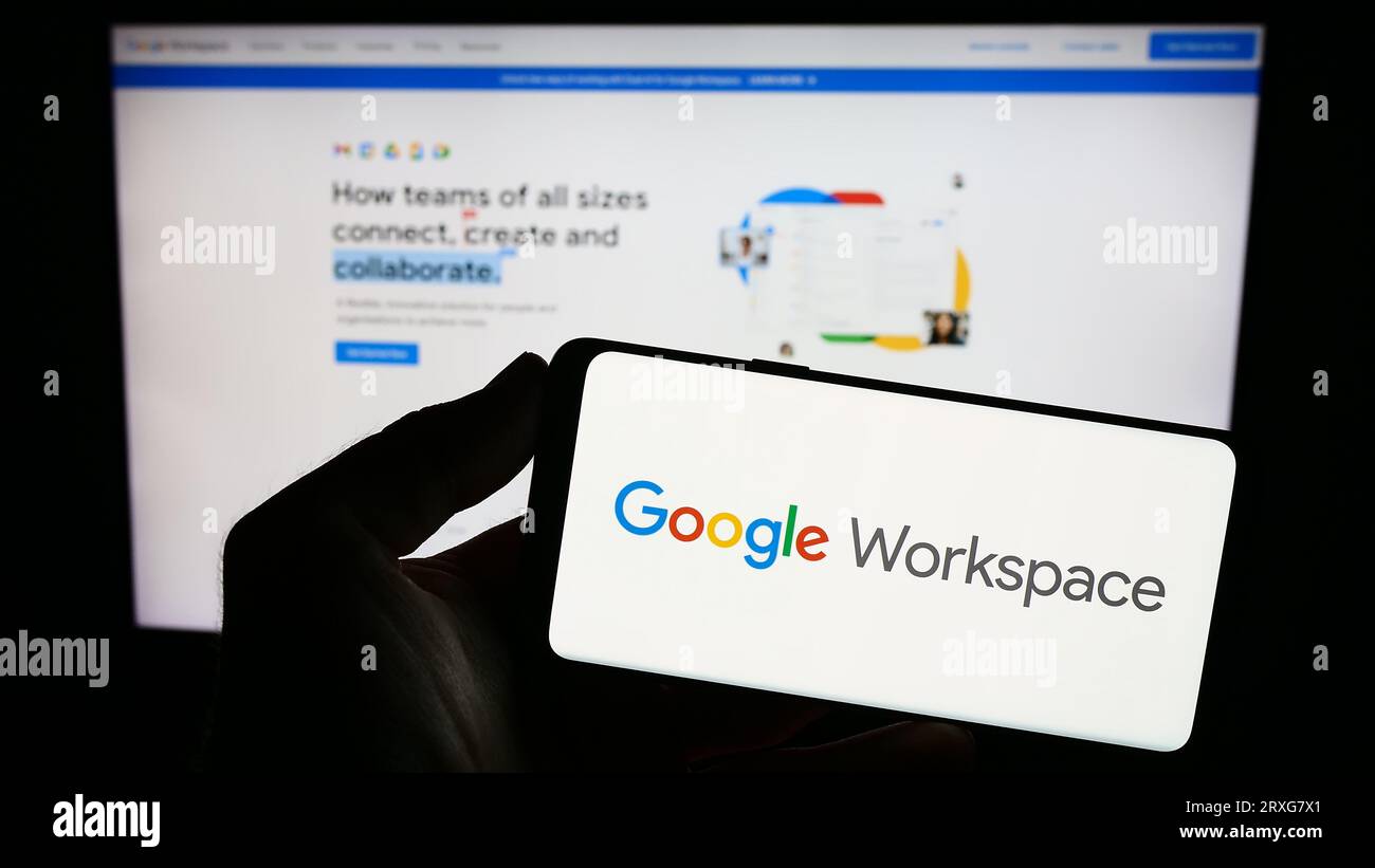 Person, die ein Smartphone mit dem Logo der Business-App-Software Google Workspace auf dem Bildschirm vor der Website hält. Konzentrieren Sie sich auf das Display des Telefons. Stockfoto