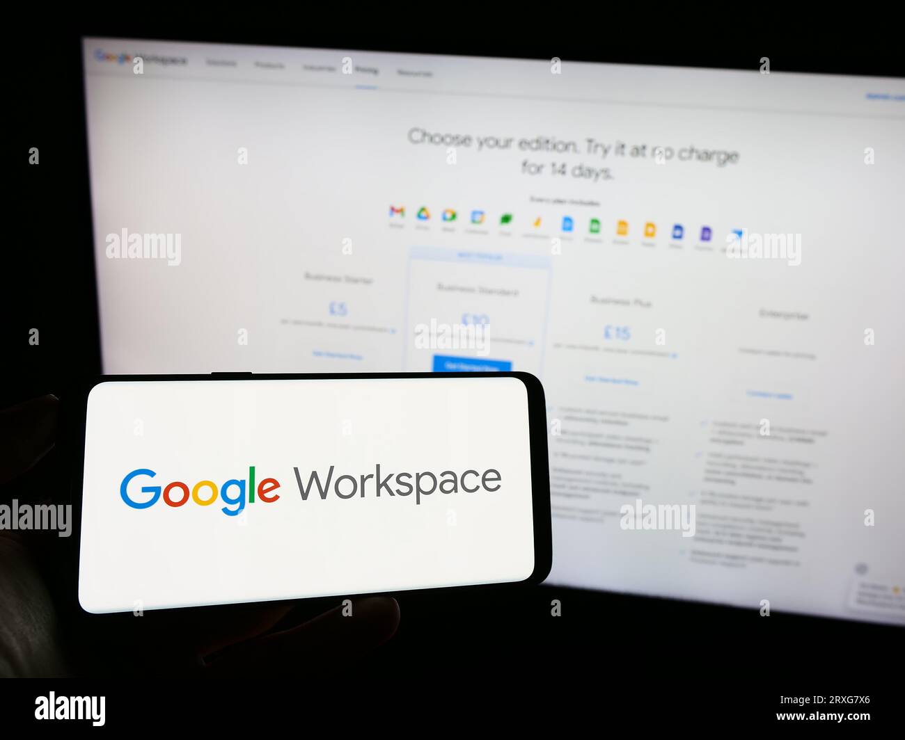 Person, die ein Mobiltelefon mit dem Logo der Business-App-Software Google Workspace auf dem Bildschirm vor der Firmenwebsite hält. Konzentrieren Sie sich auf das Display des Telefons. Stockfoto