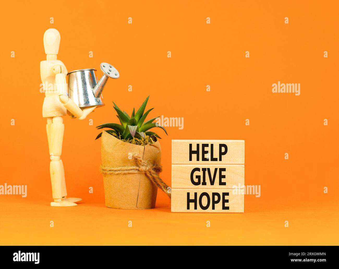 Hilf, das Symbol Hoffnung zu geben. Konzept Wort helfen Hoffnung auf schönen Holzblock zu geben. Geschäftsmann-Modell. Schöner oranger Tisch mit orangefarbenem Hintergrund. Geschäftsmonat Stockfoto