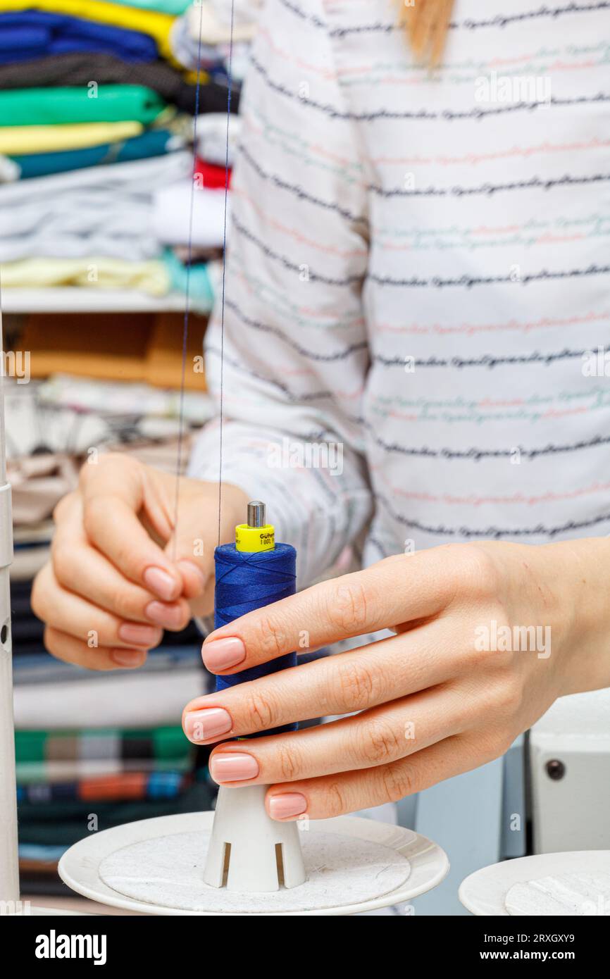 Einstellung der Nähmaschine, Gewinde in den weiblichen Händen schließen sich an Stockfoto