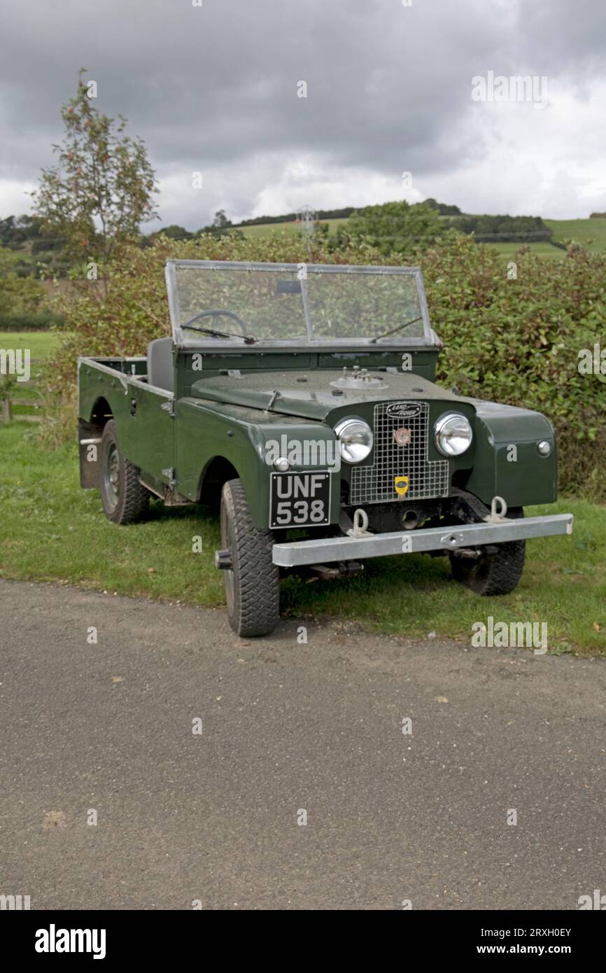 Vollständig restaurierter 1956 grüner Landrover der Serie 1, der auf Gras vor der Hecke Colemans Hill Farm Mickleton Chipping Campden UK geparkt ist Stockfoto