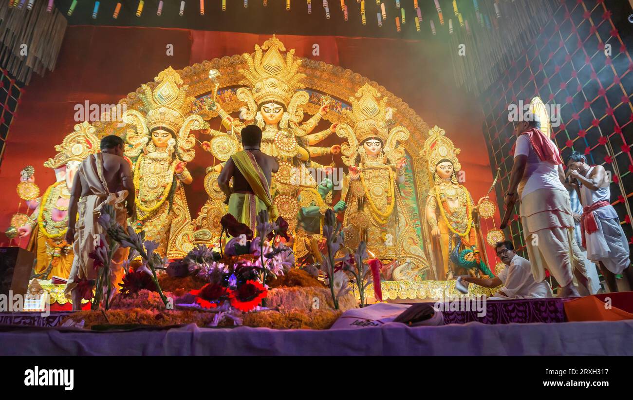 Howrah, West Bengal, Indien - 5. Oktober 2022: Hindu Purohits opfern VOG, heiliges süßes Essen für Göttin Durga, während sie sie in Durga puj verehren Stockfoto