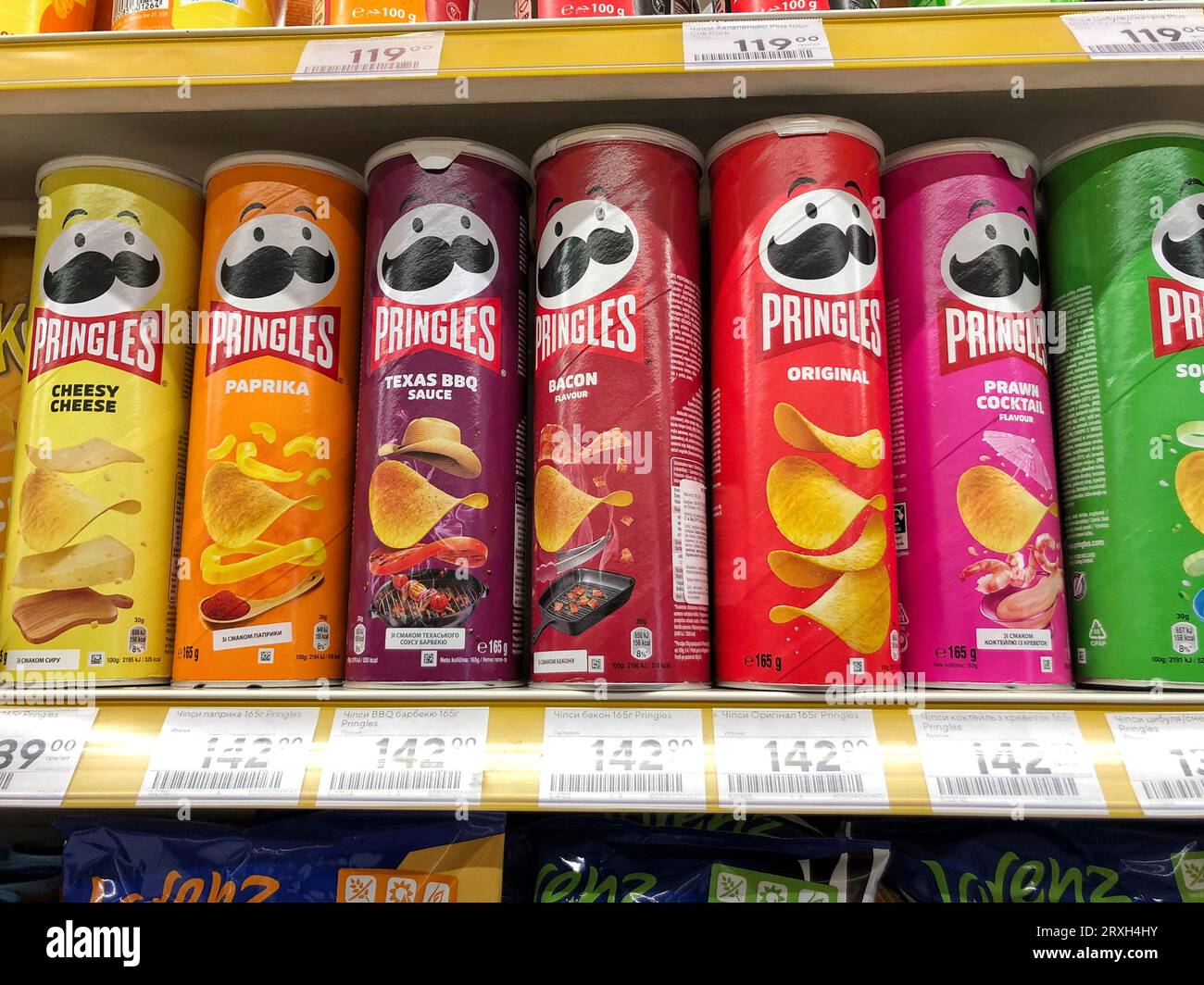 25.09.2023 Ukraine, Charkow, Pringles Chips - eine Auswahl an verschiedenen Geschmacksrichtungen. Eine Dose Chips auf einem Supermarktregal Stockfoto