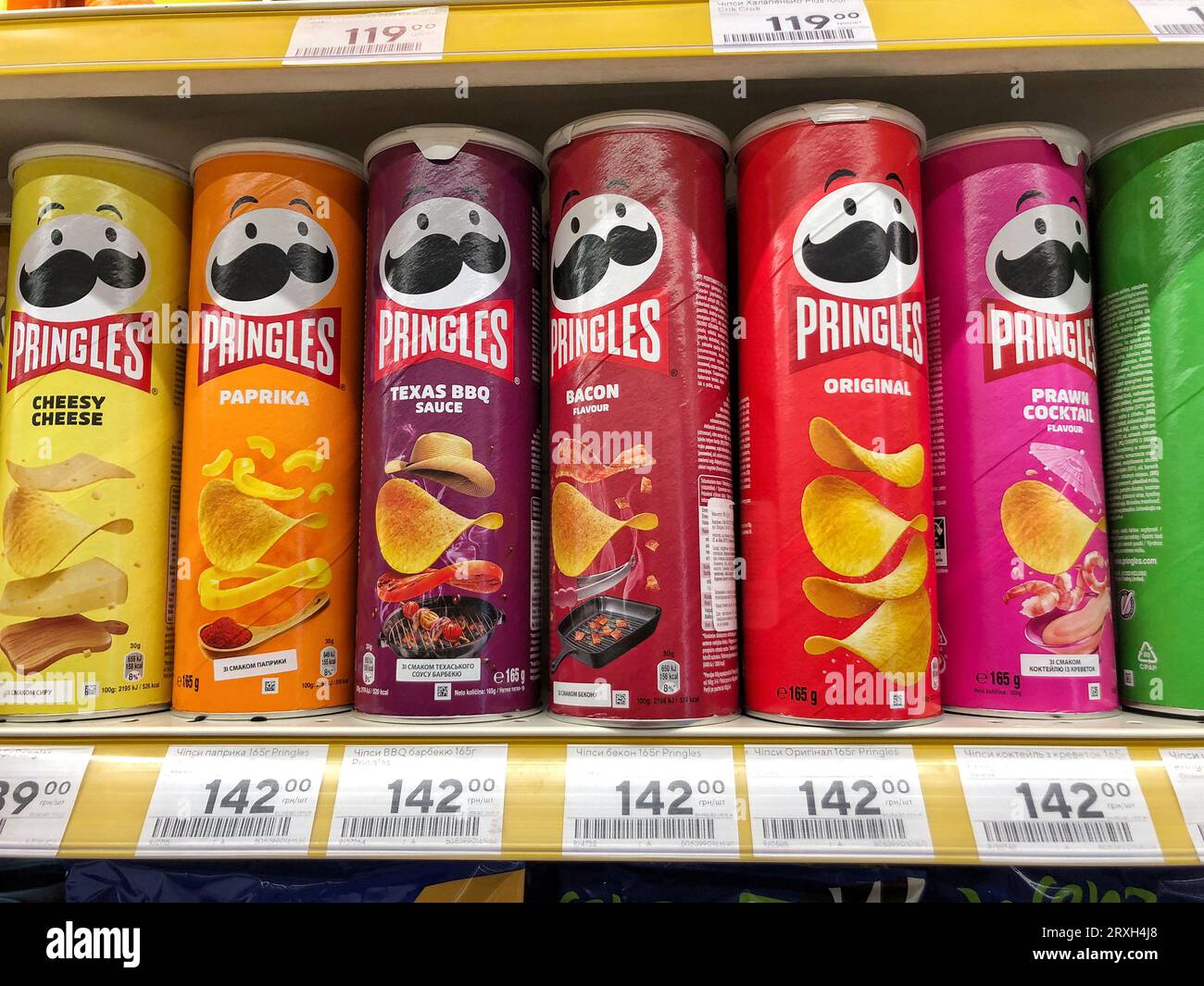 25.09.2023 Ukraine, Charkow, Pringles Chips - eine Auswahl an verschiedenen Geschmacksrichtungen. Eine Dose Chips auf einem Supermarktregal Stockfoto