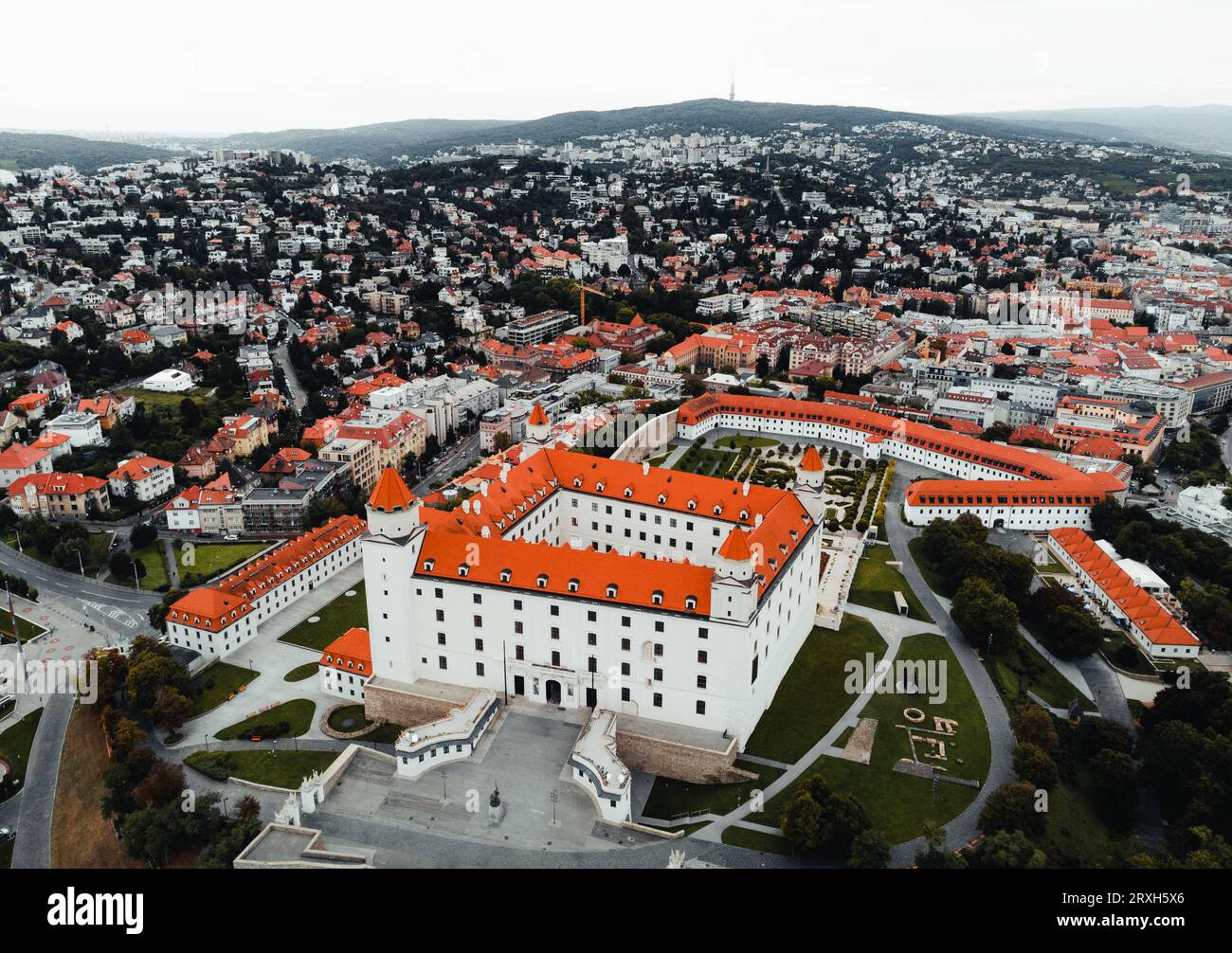 Luftaufnahme der Burg Bratislava mit Panoramablick auf die Landschaft der Stadt und den dramatischen Himmel mit Hügel im Hintergrund. Stockfoto