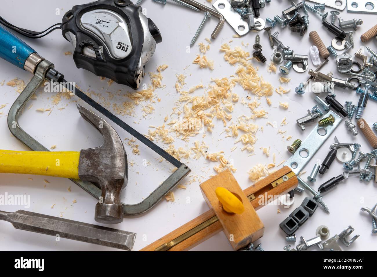 Ein Hintergrund mit Hardware, Handwerkzeugen und Holzspänen, isoliert in weiß. Stockfoto
