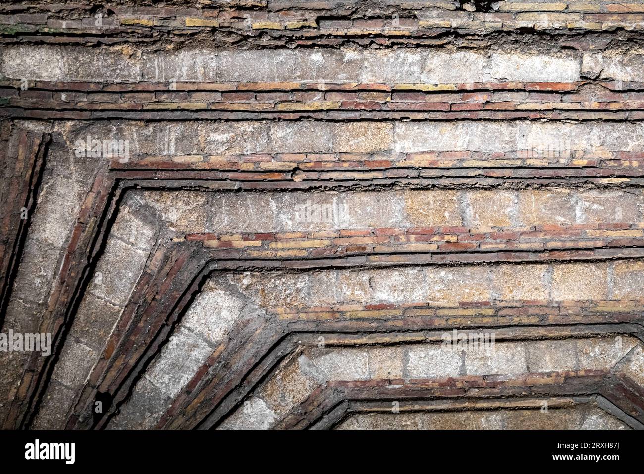 Helle und dunkle Linien und graue Steinfarben, strukturierte Decke mit Rot. Stockfoto