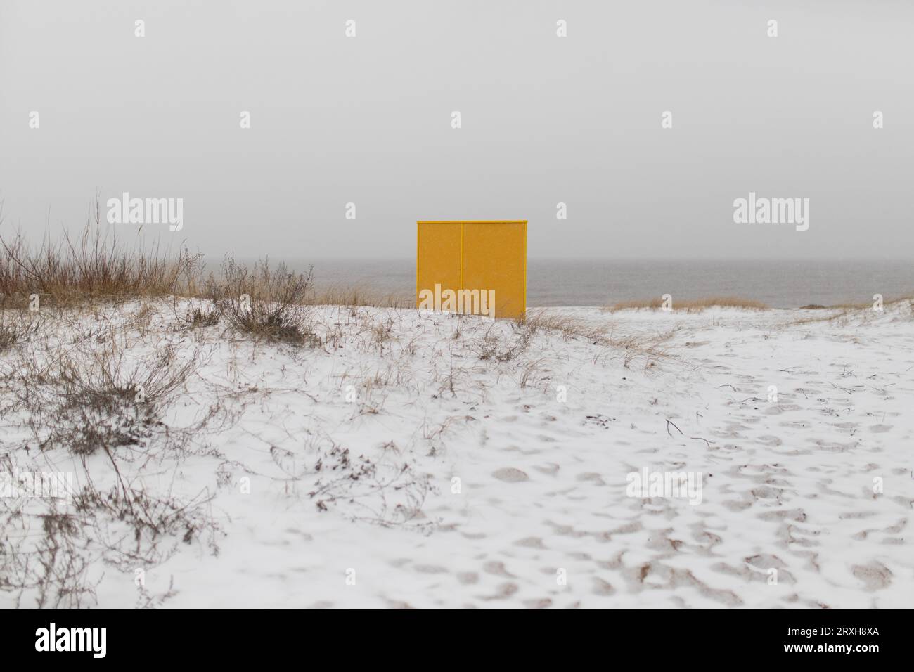 Gelber Strandumkleideraum auf Holzplattform im Winter. Stockfoto