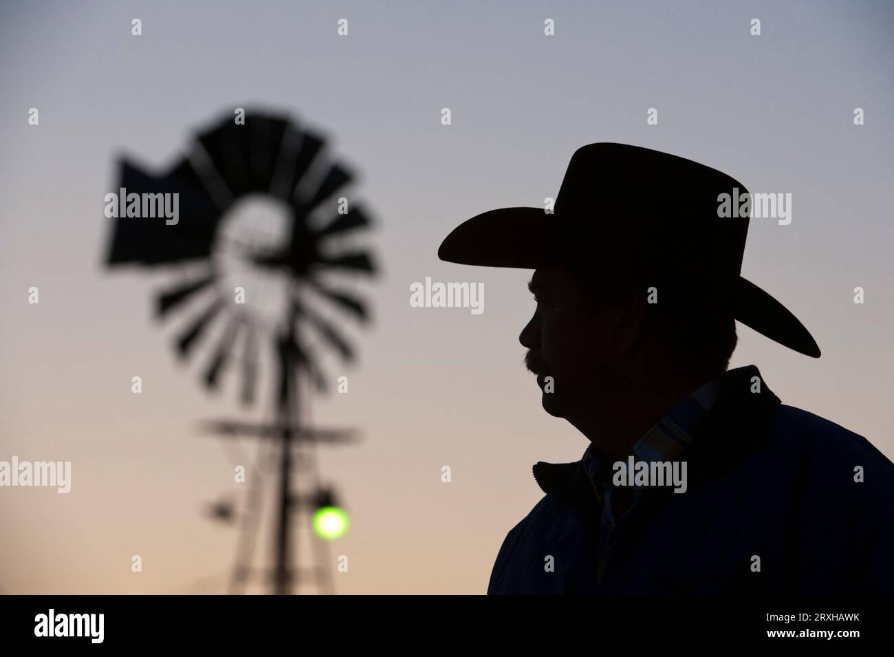 Silhouette eines Ranchers in Nebraska mit Cowboyhut bei Sonnenuntergang in den Nebraska Sandhills; Sandhills, Nebraska, Vereinigte Staaten von Amerika Stockfoto