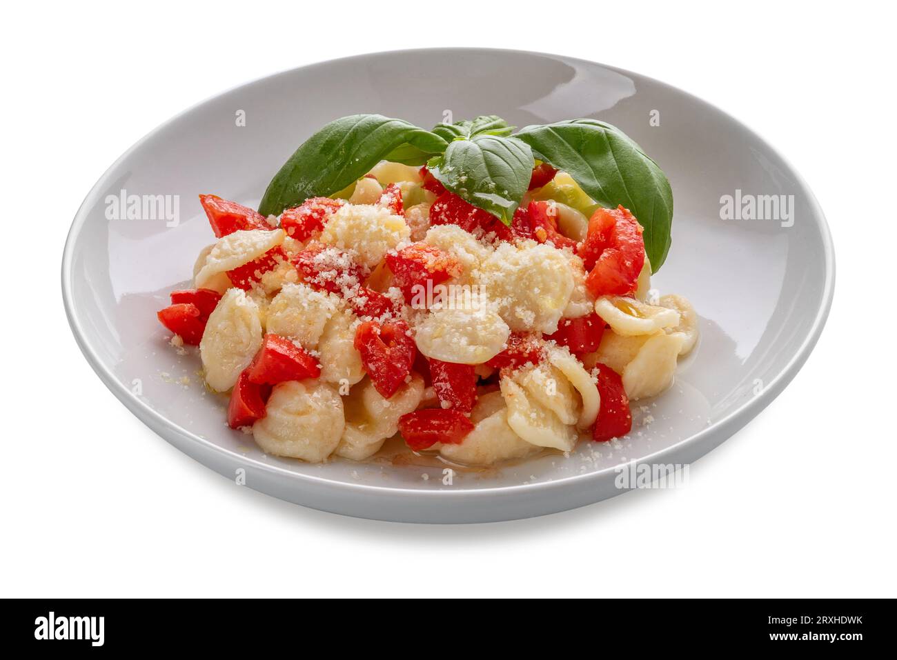 Pasta-Orecchiette mit frischer Tomate, Olivenöl und Basilikumblättern und Parmisan in weißer Platte isoliert auf weiß mit Schnittpfad Stockfoto