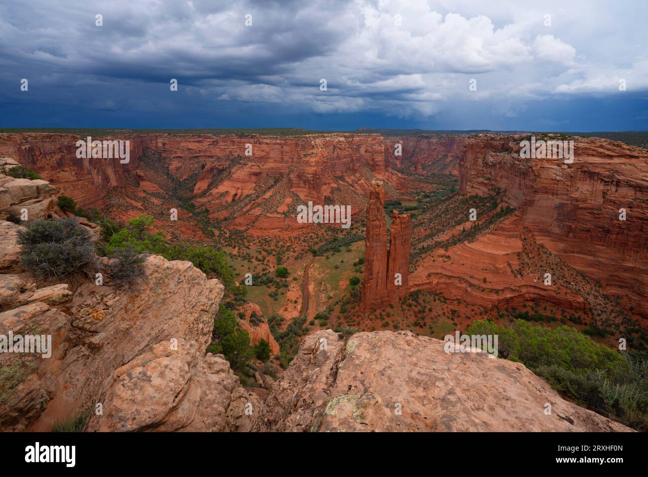 Landschaft des Canyon de Chelley, Arizona. Sturmwolken sammeln sich über dem Talboden, während die Felsformation, die als „Spinne“ bekannt ist, sich erhebt. Es ist... Stockfoto