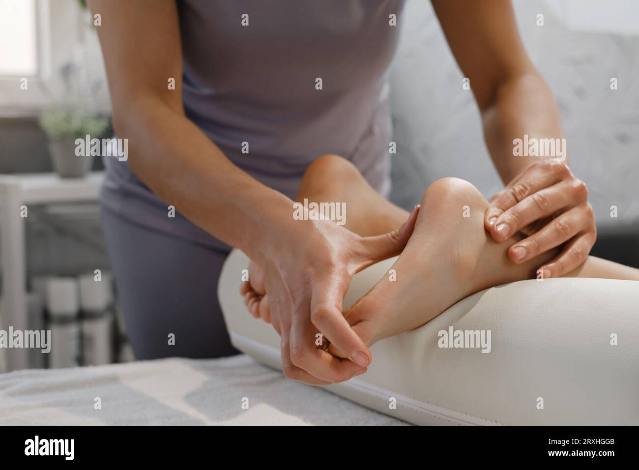 Fußmassagebehandlung für Kinder durch professionellen Masseur im Spa-Resort. Wellness, Stressabbau und Gesundheitskonzept Stockfoto