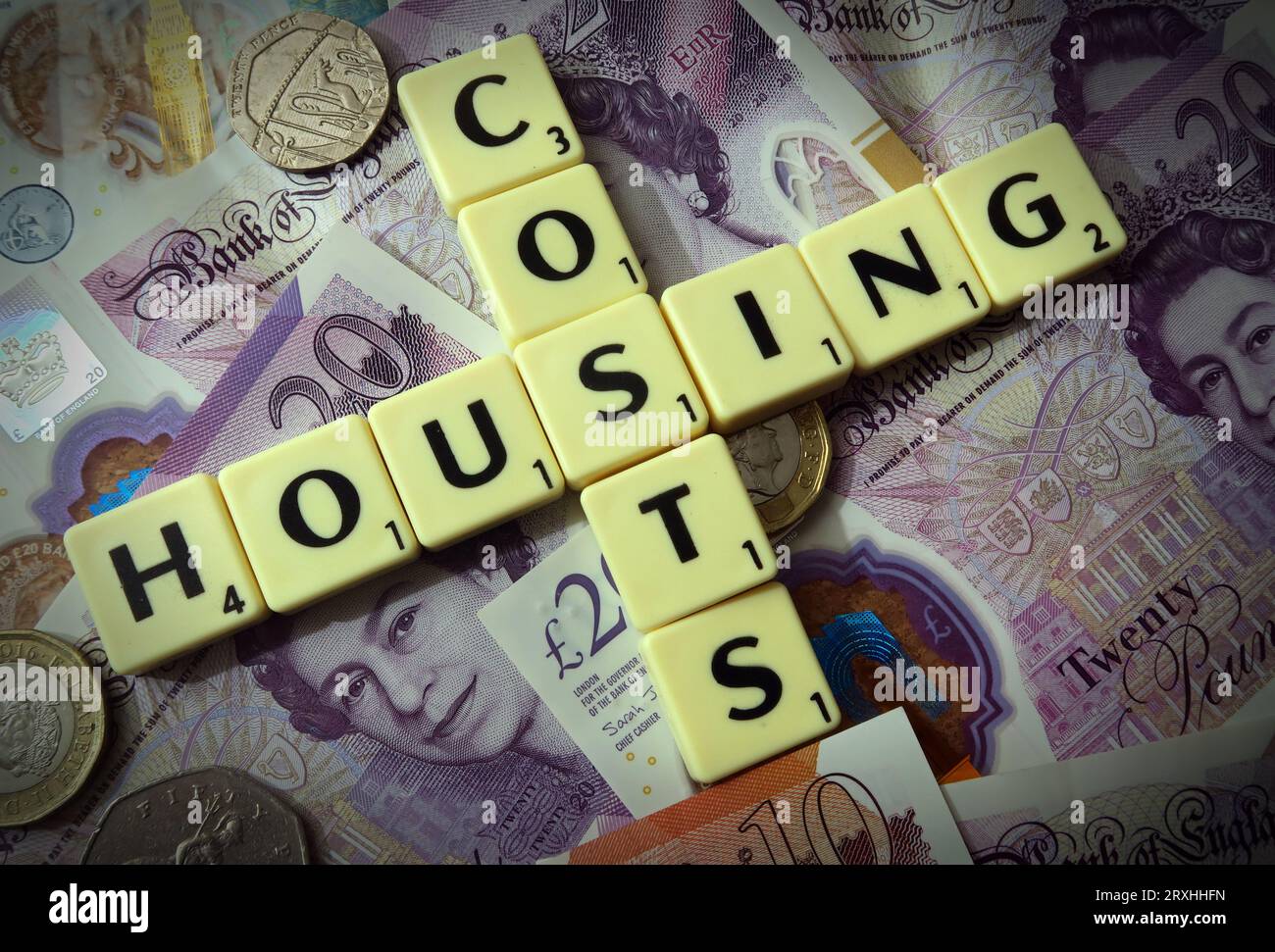 Wohnkosten - in Worten, Scrabble Briefe mit englischen und walisischen Sterling Bargeld - zwanzig Pfund, zehn Pfund, fünf Pfund Stockfoto