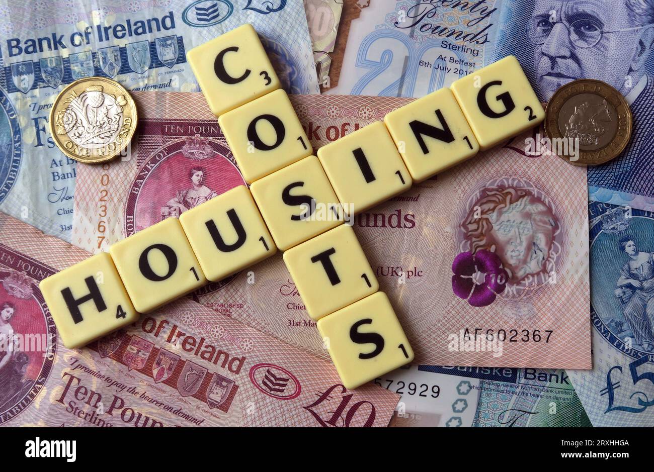Wohnkosten - in Worten, Scrabble Briefe mit Northern Irish Sterling Bargeld - zwanzig Pfund, zehn Pfund, fünf Pfund, Pfund, Pfund Stockfoto