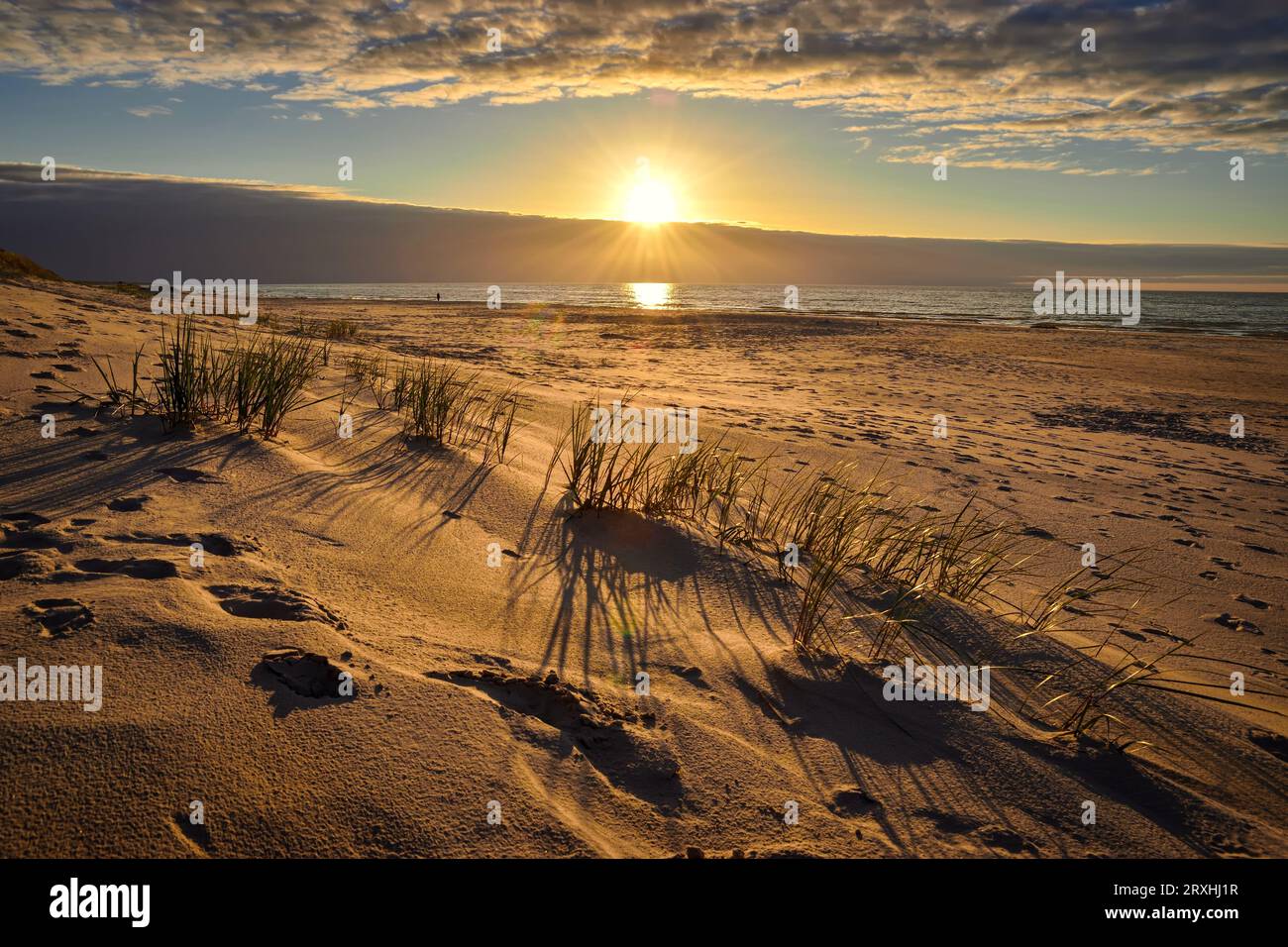 Wunderschöner Sonnenuntergang über der Ostsee in Polen. Die untergehende Sonne am Himmel und ein wunderschöner Sandstrand in Leba, Polen. Stockfoto