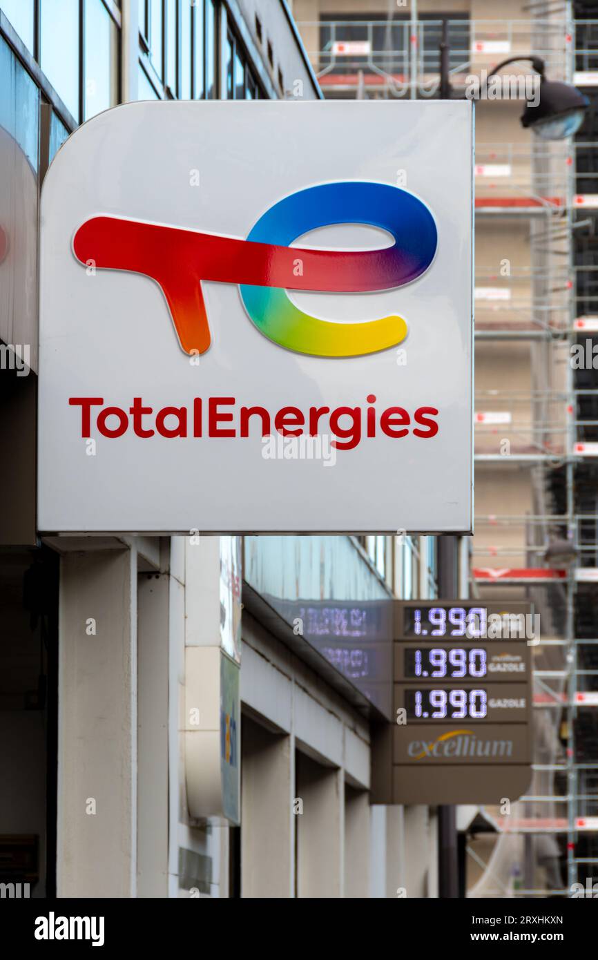 Zeichen und Logo einer Tankstelle des französischen Ölkonzerns TotalEnergies. Kraftstoffpreise werden im Hintergrund angezeigt Stockfoto