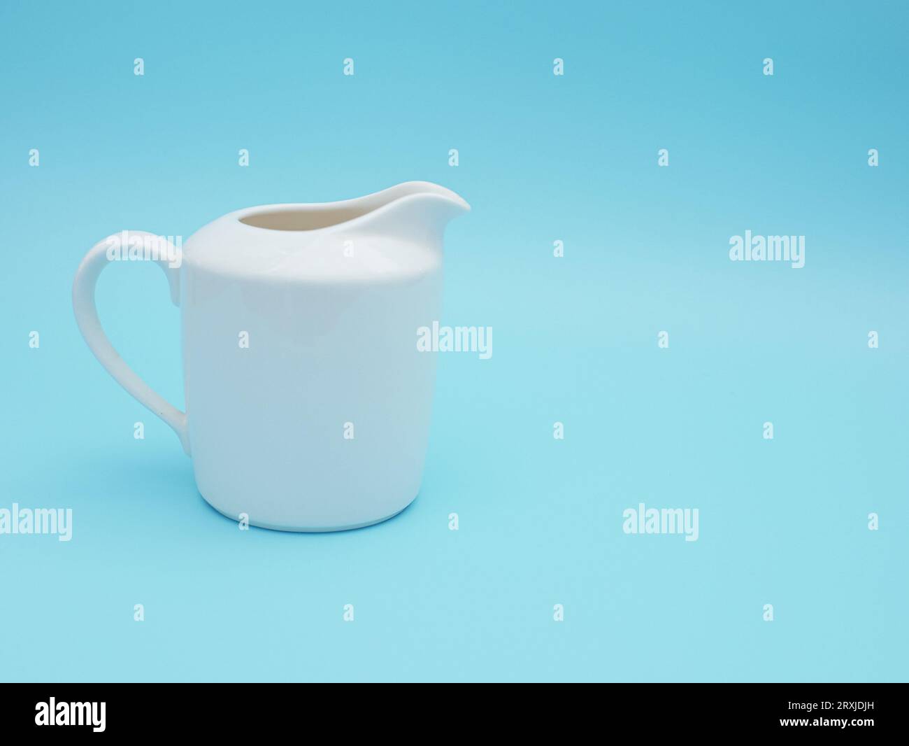 Weißer Milchkrug isoliert auf blauem Hintergrund Stockfoto