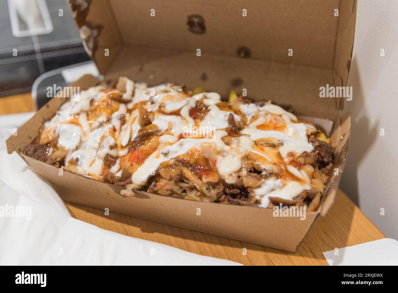 Eine Packung Halal-Snack zum Mitnehmen, ein australisches Fast-Food-Gericht, das im Wesentlichen aus Pommes frites mit Dönerfleisch und Saucen besteht. Stockfoto