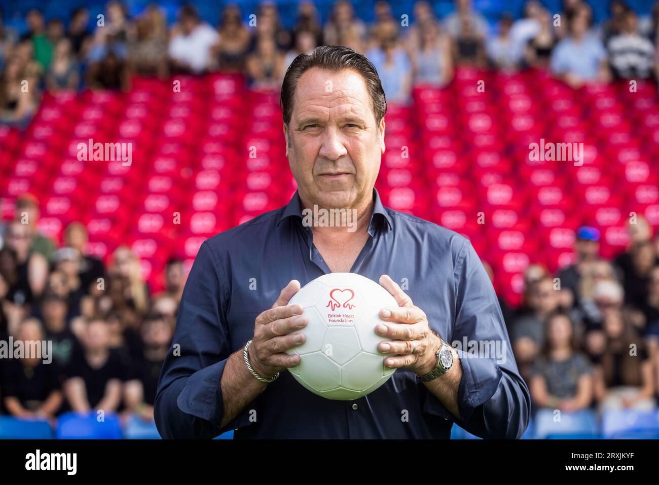 NUR David Seaman schließt sich Unterstützern an, die rund 180 leere Sitze in Form eines Herzens im Selhurst Park im Süden Londons, der Heimat des Crystal Palace F.C., halten, um die Zahl der Toten zu repräsentieren, die in Großbritannien durch die koronare Herzkrankheit täglich verloren wurden. für eine Kampagne der British Heart Foundation, um Herzerkrankungen ins Zentrum zu rücken. Ausgabedatum: Dienstag, 26. September 2023. Stockfoto