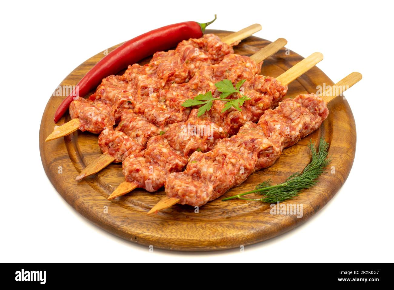 Adana-Kebab isoliert auf weißem Hintergrund. Roher Shish adana Kebab mit Kräutern und Gewürzen Stockfoto