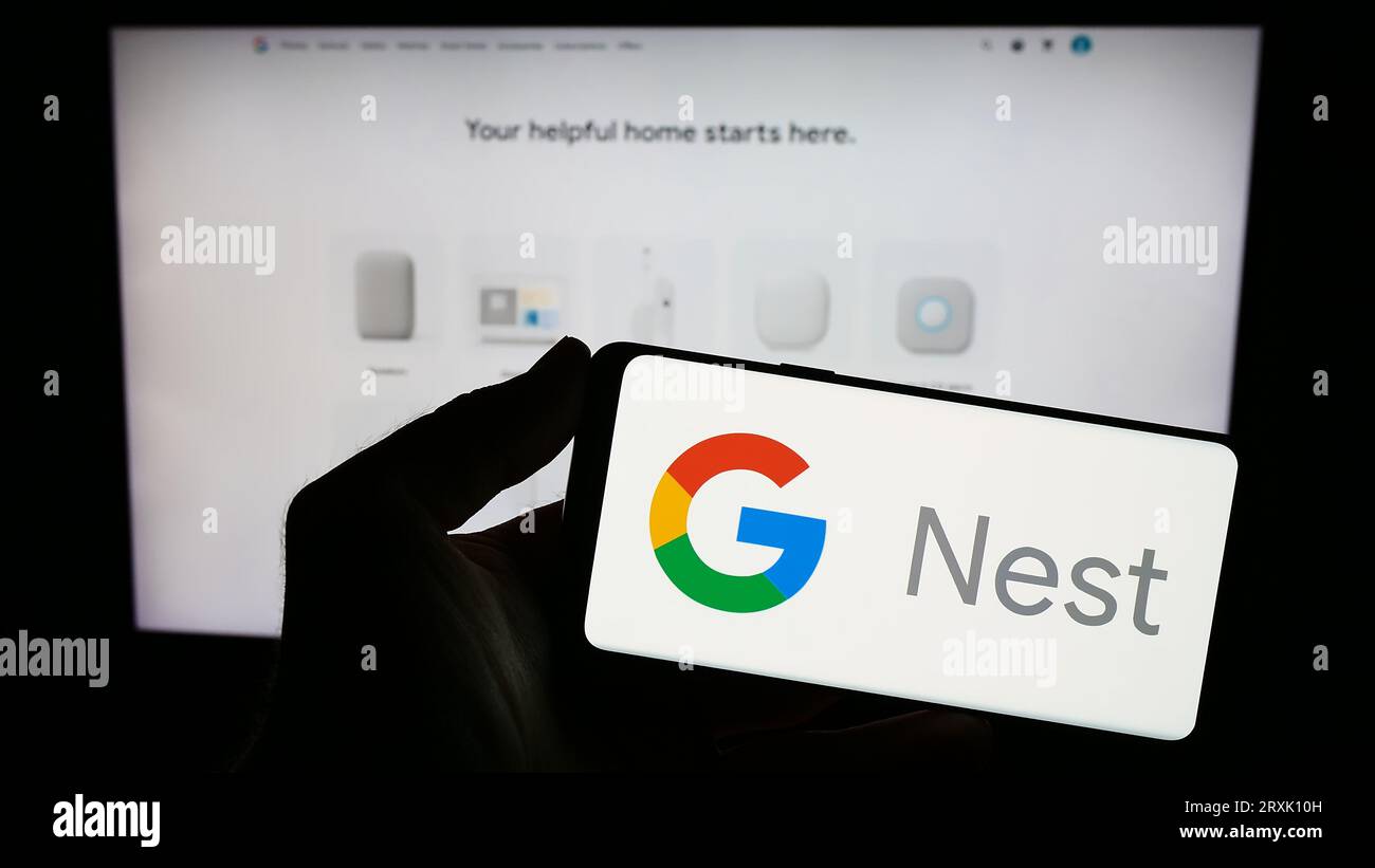 Person, die ein Smartphone mit dem Logo der Smart-Home-Plattform Google Nest auf dem Bildschirm vor der Website hält. Konzentrieren Sie sich auf das Display des Telefons. Stockfoto