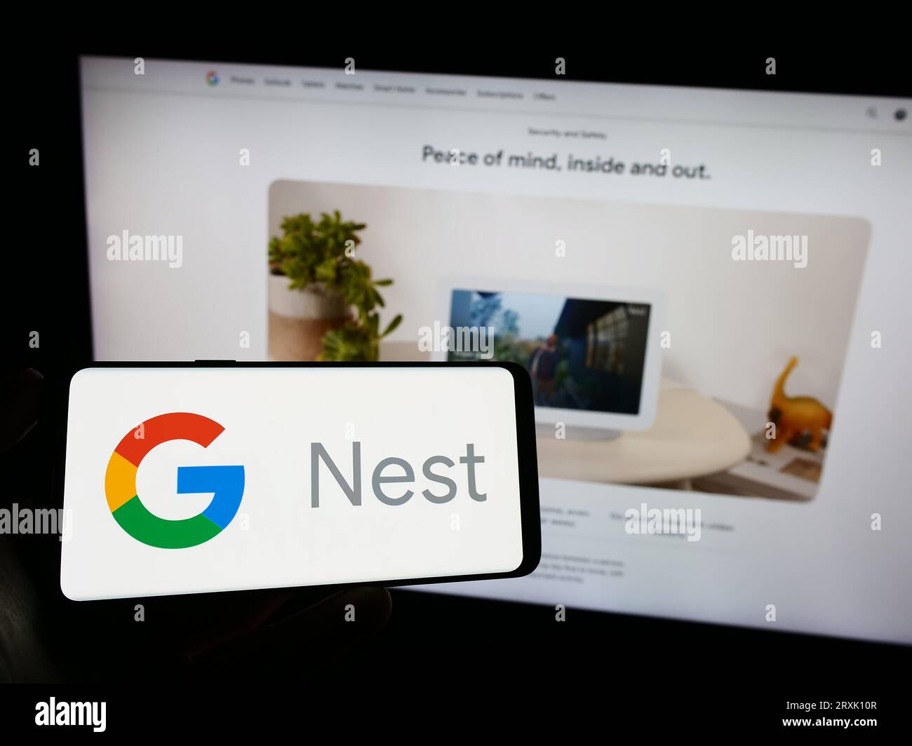 Person, die ein Mobiltelefon mit dem Logo der Smart-Home-Plattform Google Nest auf dem Bildschirm vor der Firmenwebsite hält. Konzentrieren Sie sich auf das Display des Telefons. Stockfoto