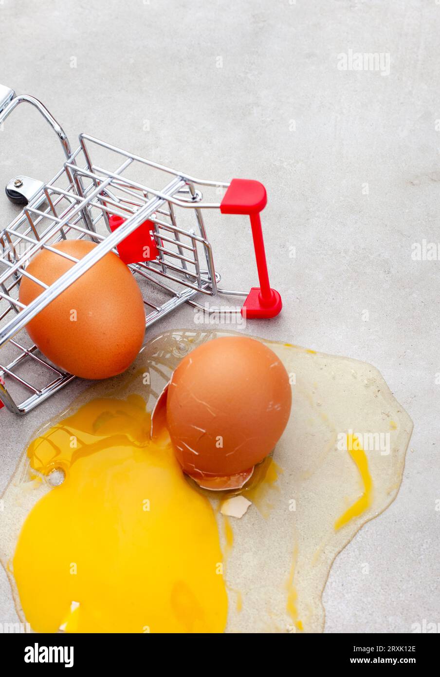 Warenkorb mit gebrochenem Ei auf hellgrau, Eiermangel Stockfoto