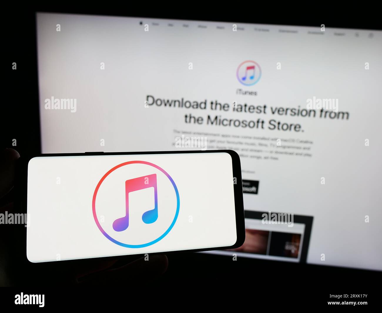 Person, die ein Smartphone mit dem Logo des Mediensoftwareprogramms Apple iTunes auf dem Bildschirm vor der Website hält. Konzentrieren Sie sich auf das Display des Telefons. Stockfoto