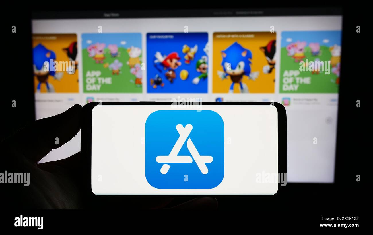 Person, die ein Smartphone mit dem Logo der Marketplace-Plattform Apple App Store auf dem Bildschirm vor der Website hält. Konzentrieren Sie sich auf das Display des Telefons. Stockfoto