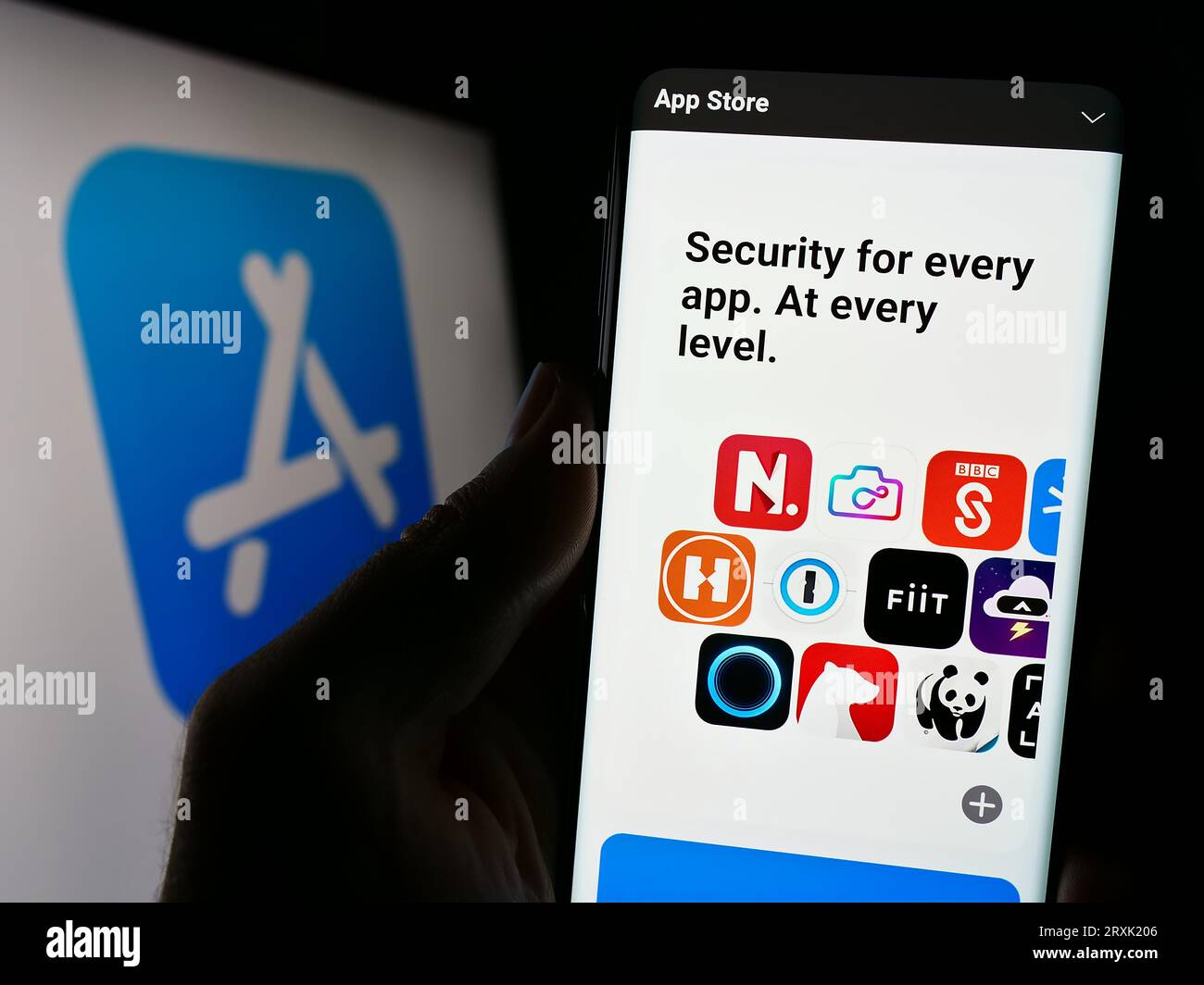 Person, die ein Mobiltelefon mit der Webseite der Marketplace-Plattform Apple App Store auf dem Bildschirm vor dem Logo hält. Konzentrieren Sie sich auf die Mitte der Telefonanzeige. Stockfoto
