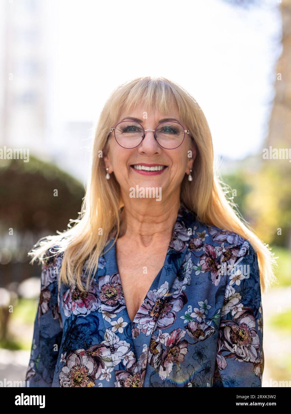 Porträt einer glücklichen Seniorin mit Brille, die draußen steht Stockfoto