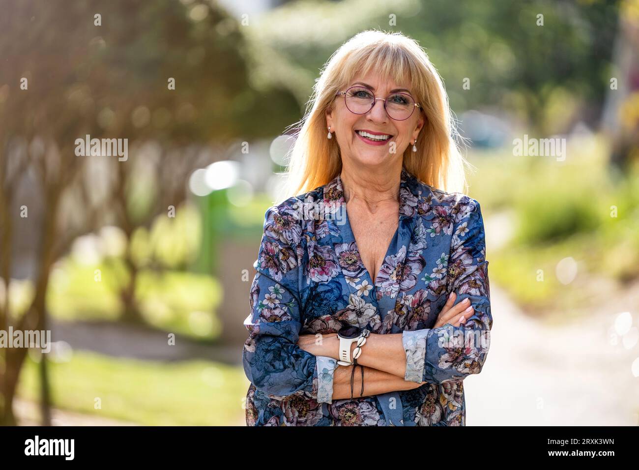 Porträt einer glücklichen Seniorin mit Brille, die draußen steht Stockfoto