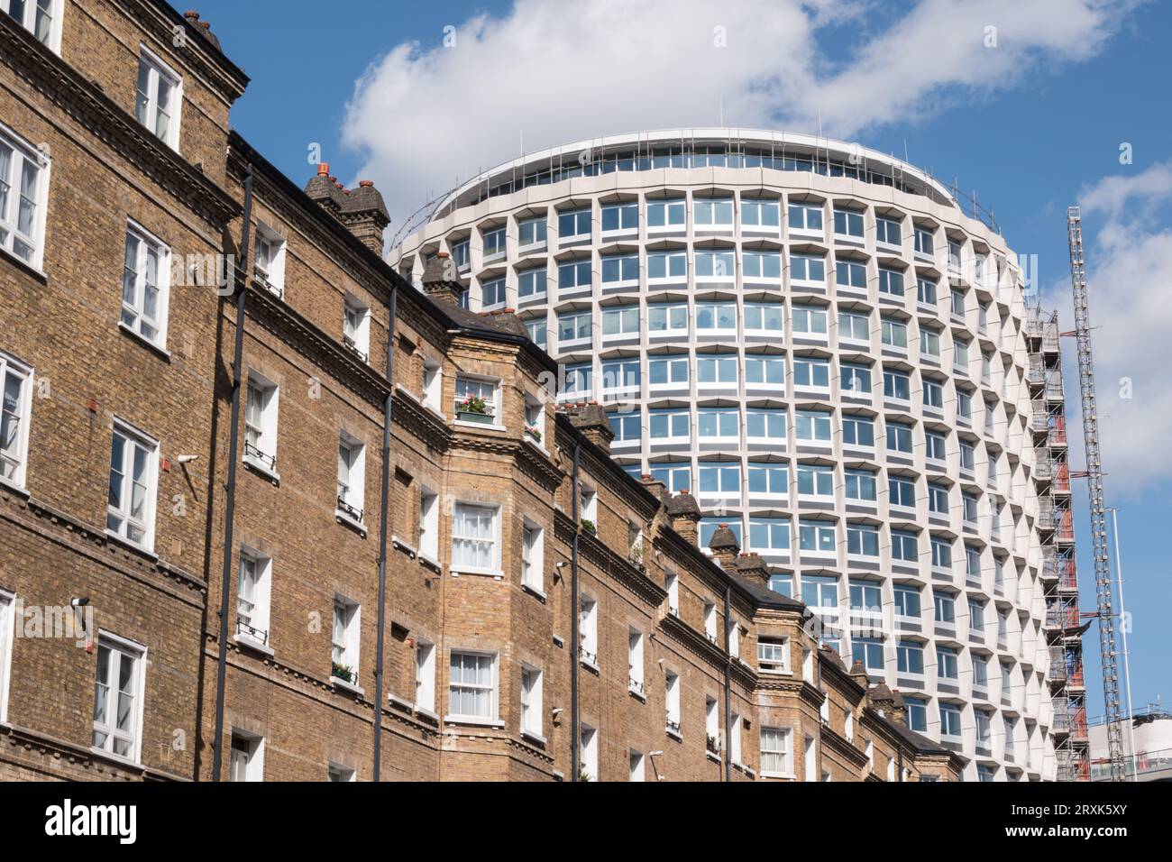 Die brutalistische Fassade von Harry Hyams' Space House in der Kemble Street neben Häusern auf dem Peabody Trust Estate, London, WC2, England, Großbritannien Stockfoto