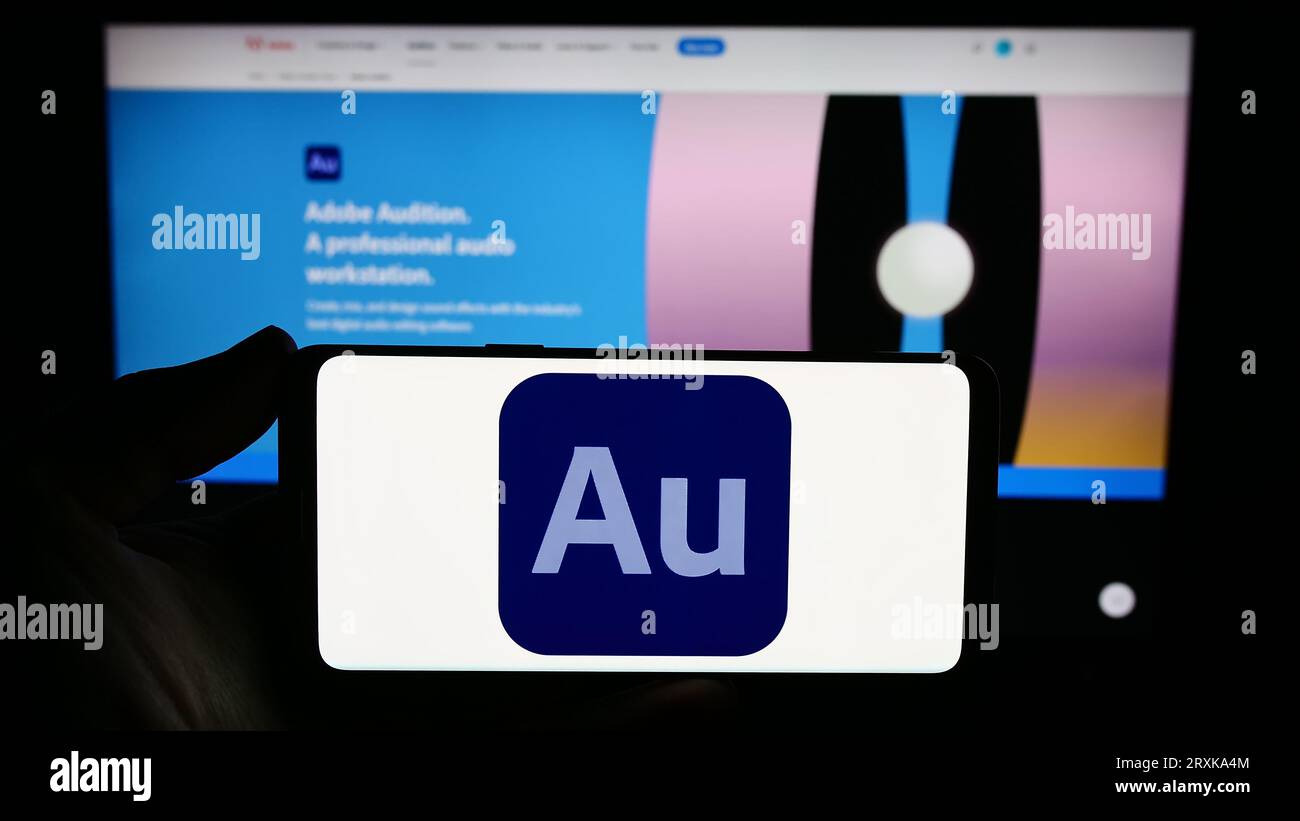 Person mit Smartphone und Logo der digitalen Audio-Workstation Adobe Audition auf dem Bildschirm vor der Website. Konzentrieren Sie sich auf das Display des Telefons. Stockfoto