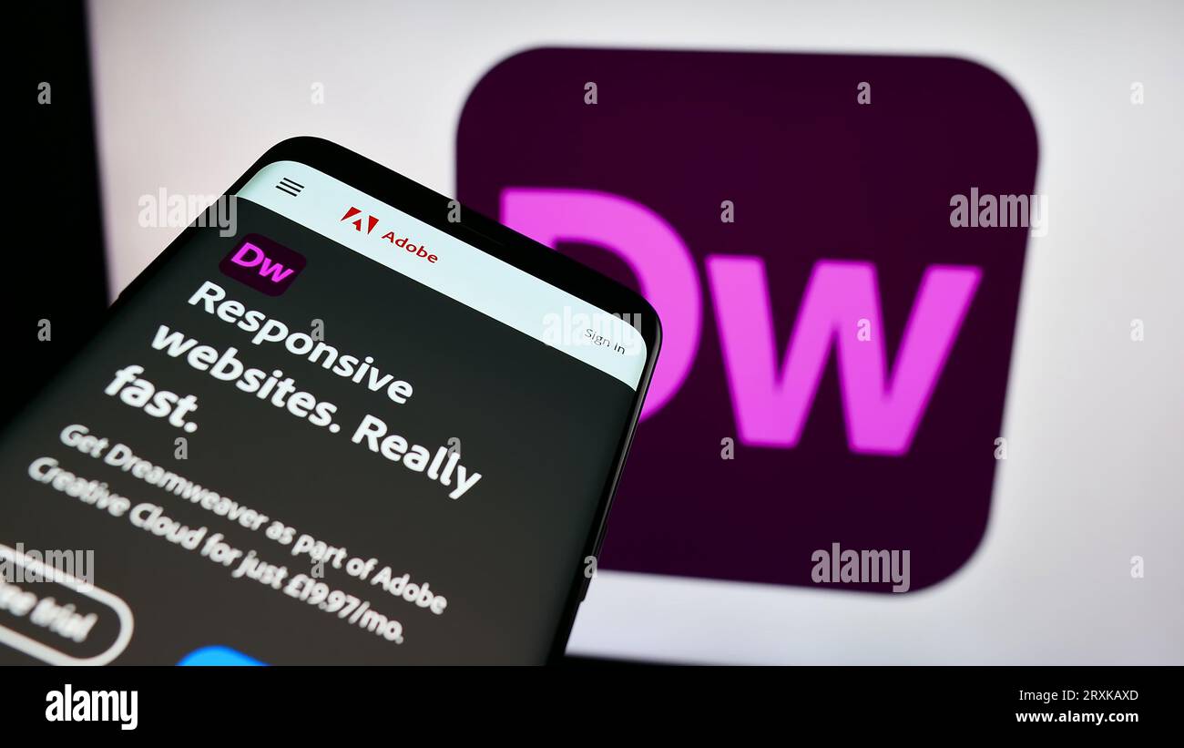 Mobiltelefon mit Website der Webentwicklungssoftware Adobe Dreamweaver auf dem Bildschirm vor dem Firmenlogo. Konzentrieren Sie sich auf die obere linke Ecke des Telefondisplays. Stockfoto
