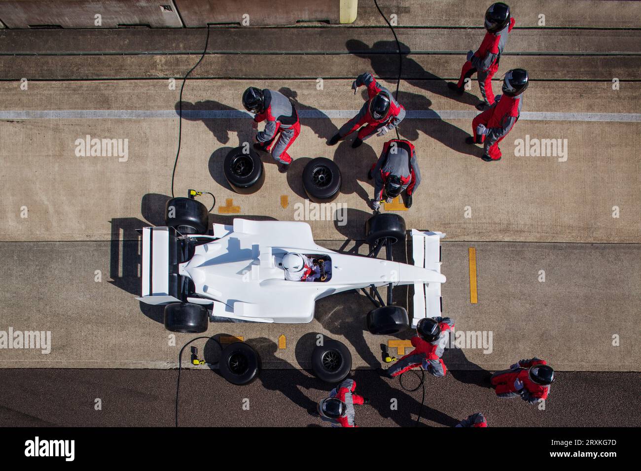 Boxencrew in perfekter Synchronisierung während eines Boxenstopps am Tag eines Highspeed-Rennens. Stockfoto
