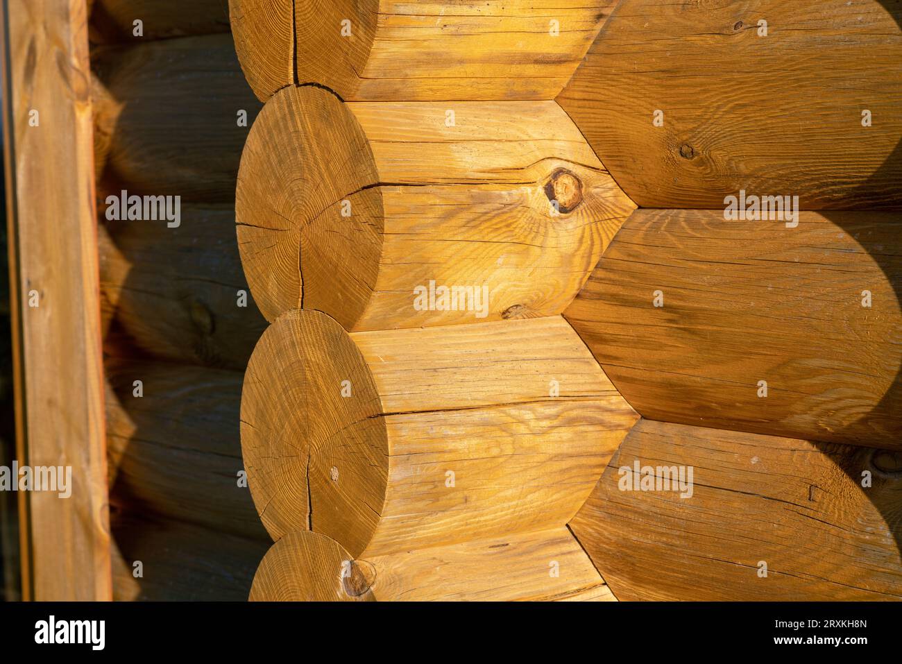 Holzgebäude mit Baudetails und Fassade mit freiliegenden Holzbalken. Ineinander greifende Balkenstruktur. Architektur, Design. Stockfoto