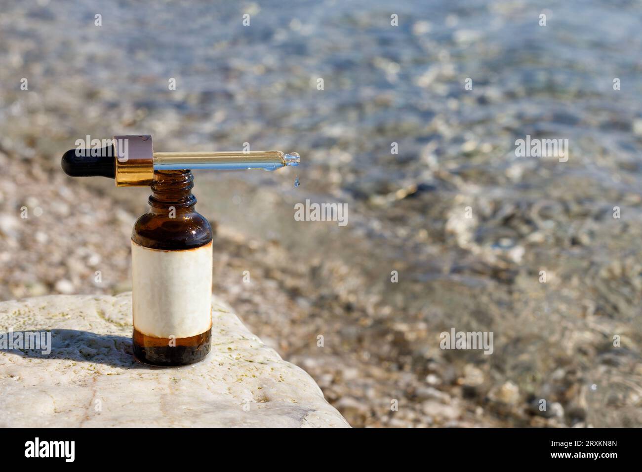 Serum Bottle Mockup auf Sea Rocks für schöne Haut, Mock-up. Stockfoto