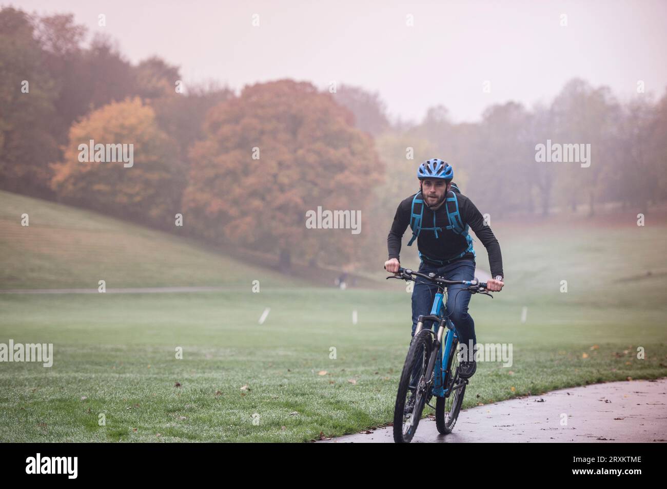 Mann das Pendeln mit dem Fahrrad durch den Park Stockfoto