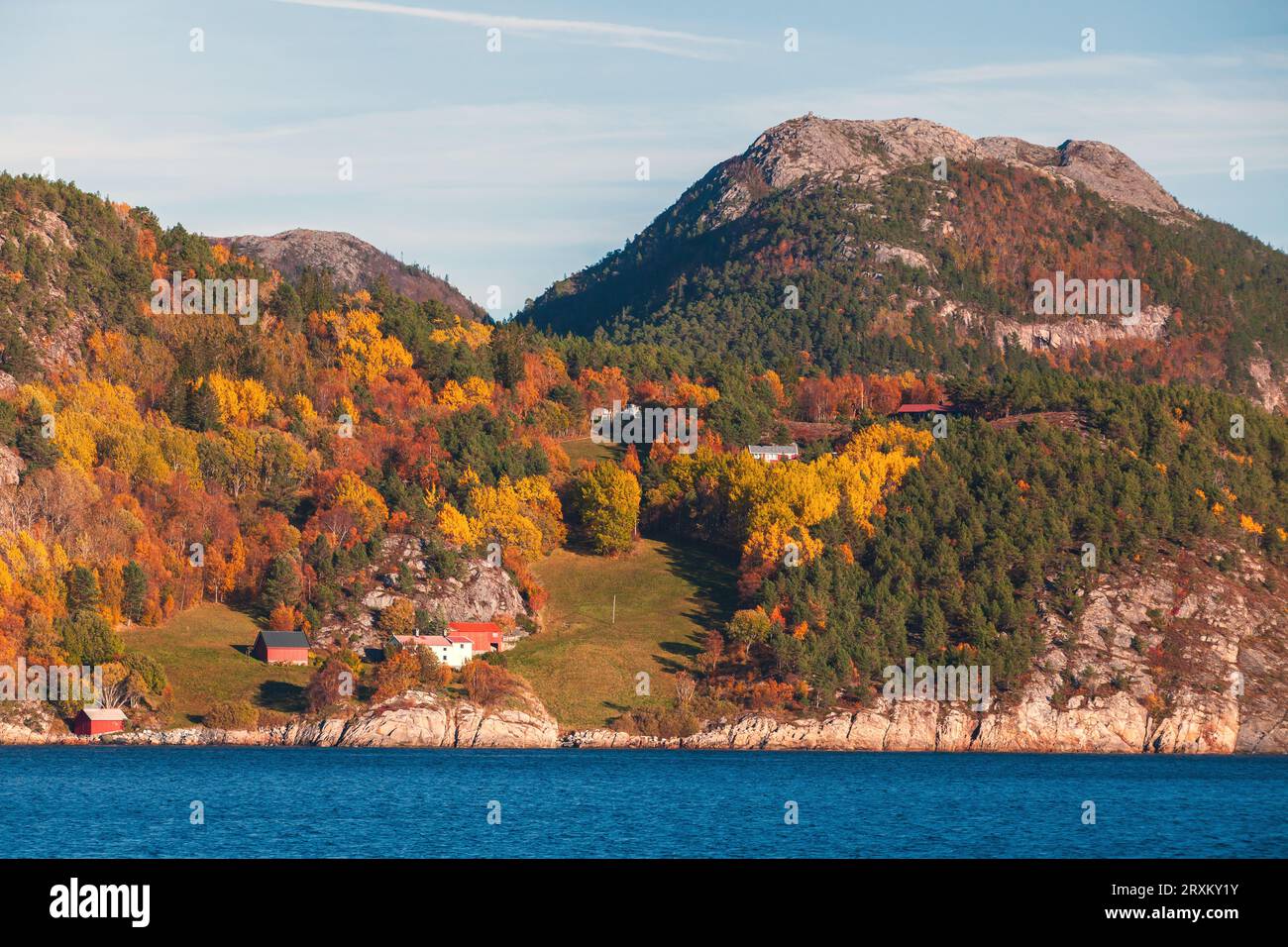 Norwegische Herbstlandschaft mit Holzhäusern und Bäumen an einer felsigen Küste eines Fjords Stockfoto