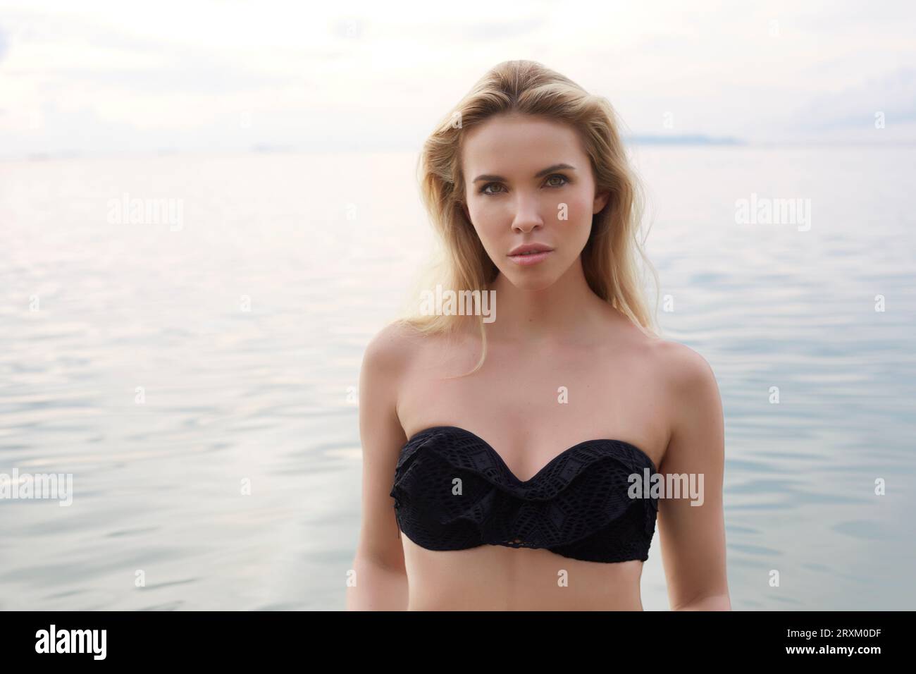 Junge Frau mit schwarzen Bikini im Meer stehend Stockfoto