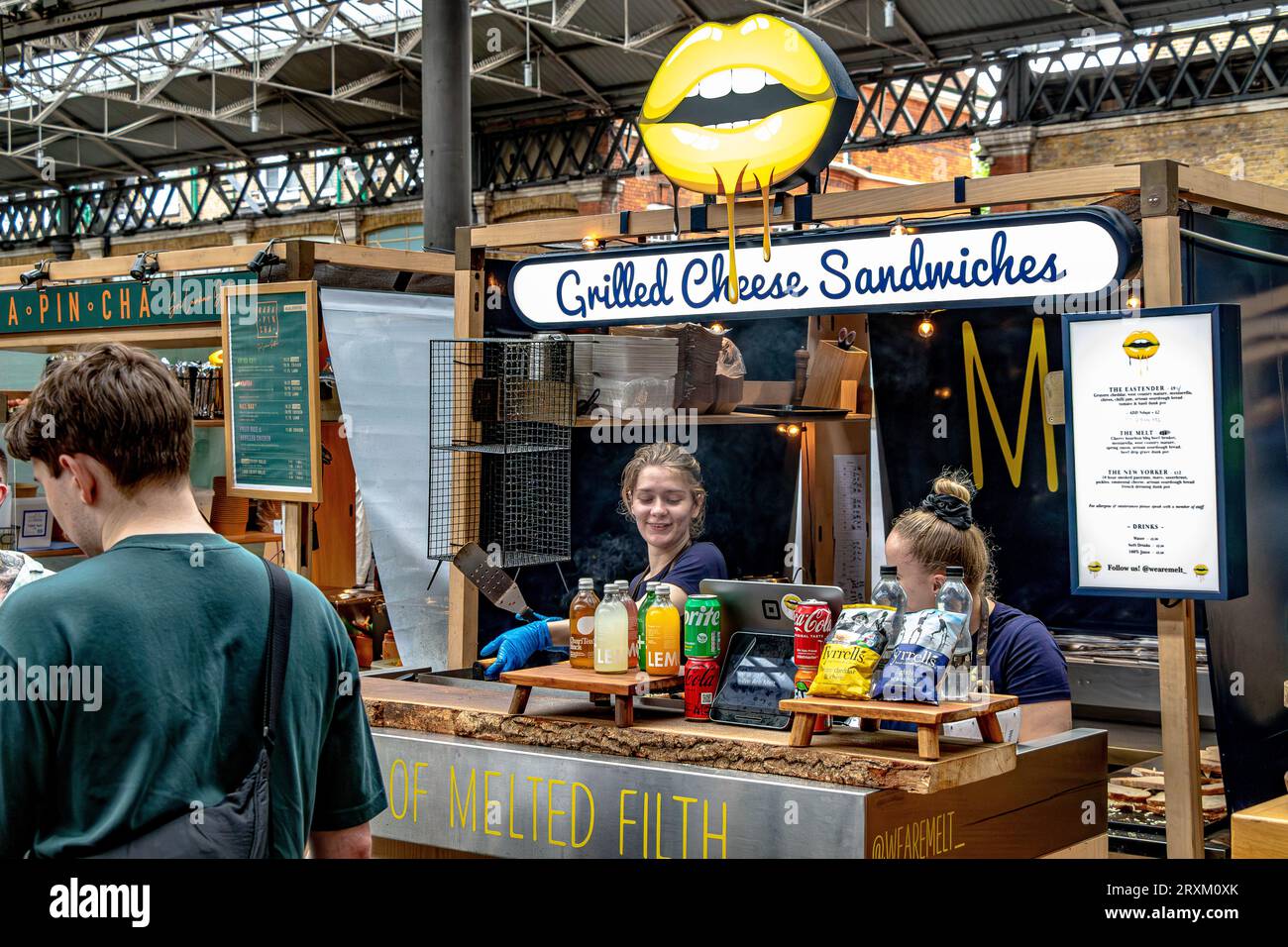 Köche bereiten gegrillte Käsesandwiches an einem Stand im Old Spitalfileds Market, London E1 Stockfoto