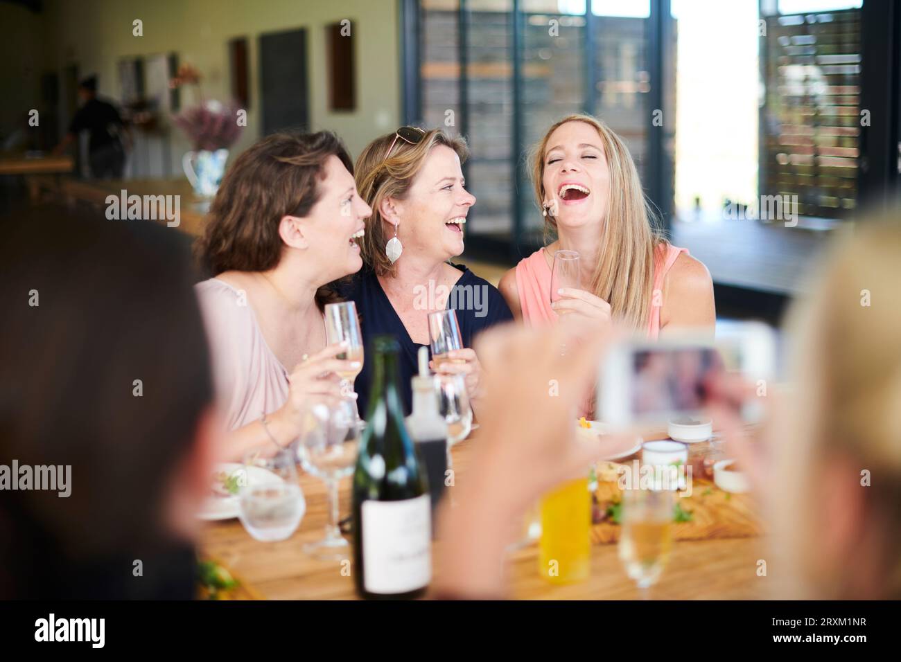 Frauen lachen beim Mittagessen mit Freunden Stockfoto