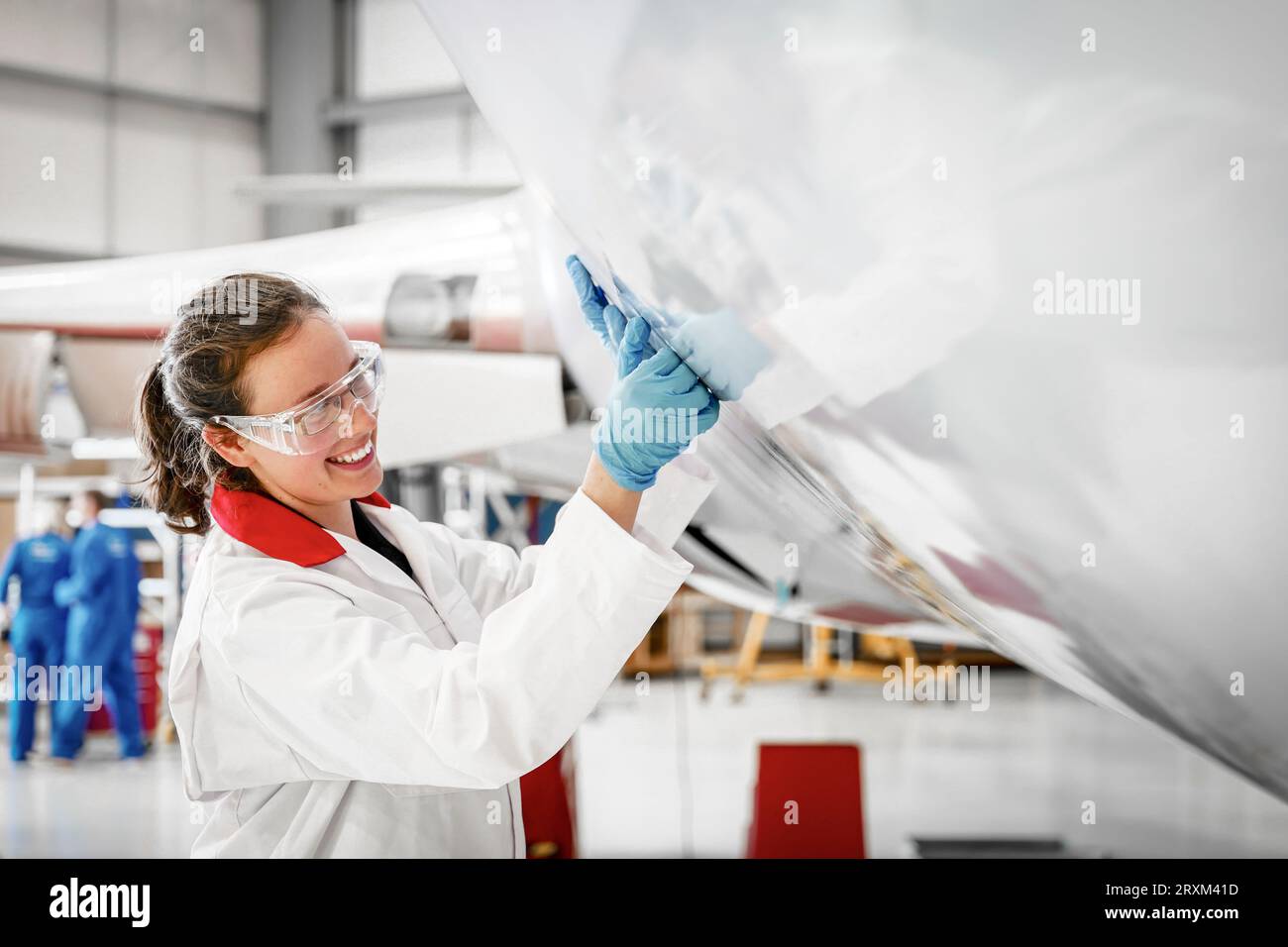Lächelnde Frau, die im Flugzeug arbeitet Stockfoto