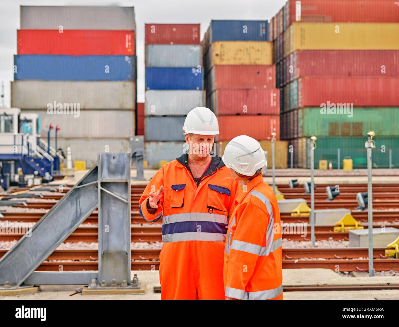 Hafenarbeiter sprechen durch Eisenbahnschienen Stockfoto