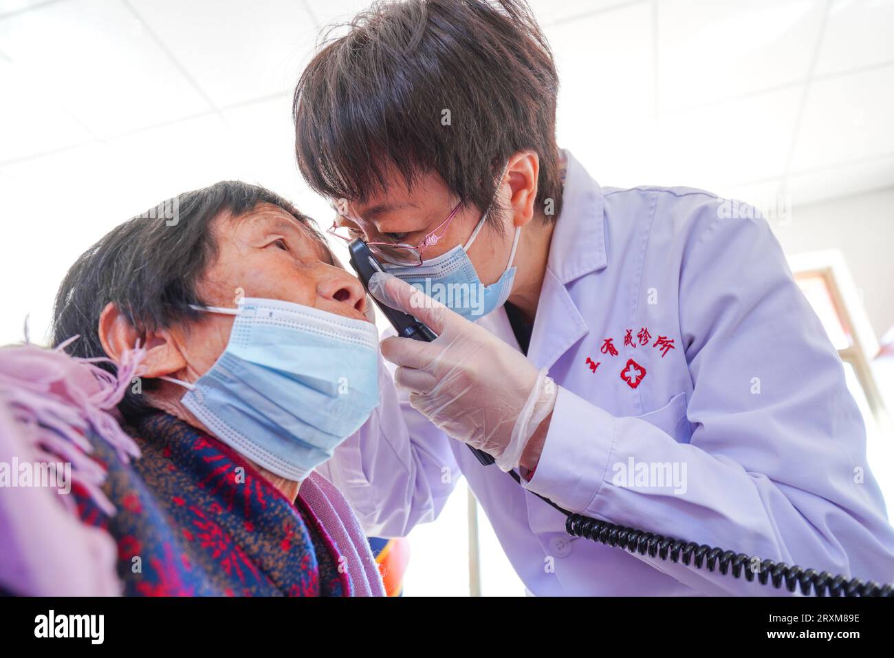 Luannan County, China - 7. April 2023: Augenärzte untersuchen Patienten auf Augenerkrankungen in einer kostenlosen Klinik. Stockfoto