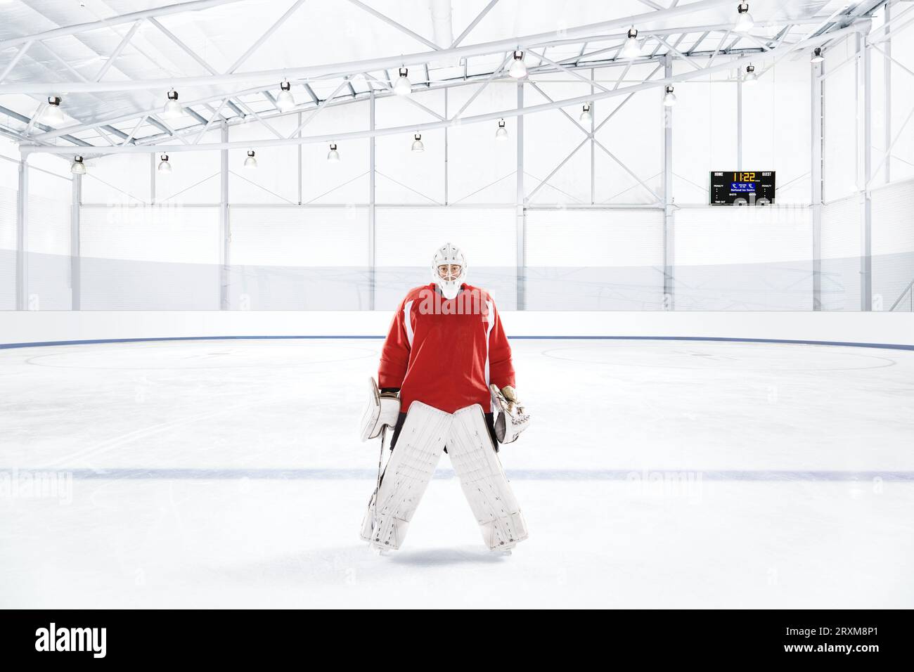 Eishockey Torwart das Tragen der roten Uniform an eine Eisbahn Stockfoto