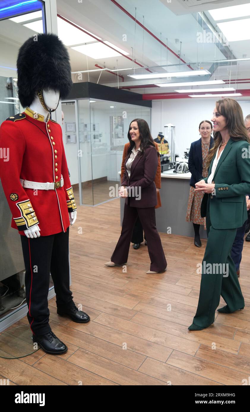 Die Prinzessin von Wales schaut auf eine scharlachrote Tunika der Guardsmans während eines Besuchs in AW Hainsworth in Leeds, einer 1783 gegründeten, familiengeführten Textilfabrik, die britische Wollstoffe, hochleistungsfähige technische Textilien und Stoffe herstellt. 1958 verkaufte der Ururgroßvater der Prinzessin William Lupton & Co an AW Hainsworth. Bilddatum: Dienstag, 26. September 2023. Stockfoto