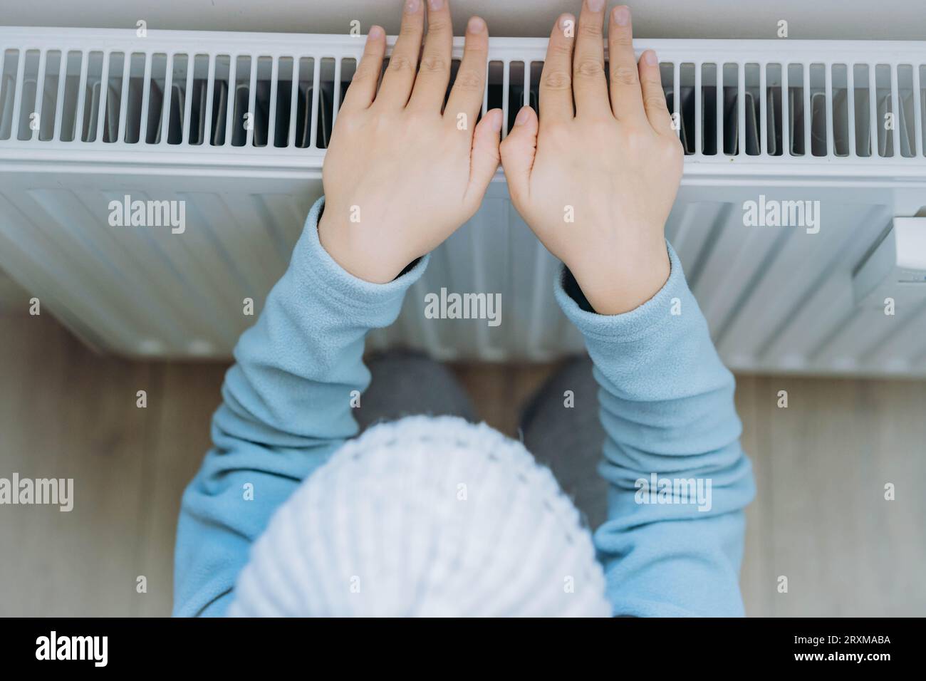 Erwärmen der Hände über dem Heizelement für Kinder. Energiekrise in Europa. Bild mit selektivem Fokus Stockfoto